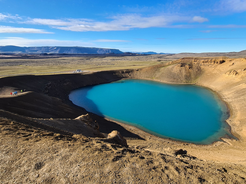 Lac turcoaz într-un crater cu versanți golași