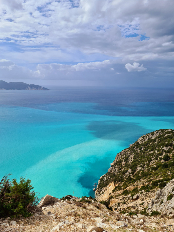 Mare turcoaz văzută de pe o coastă stâncoasă