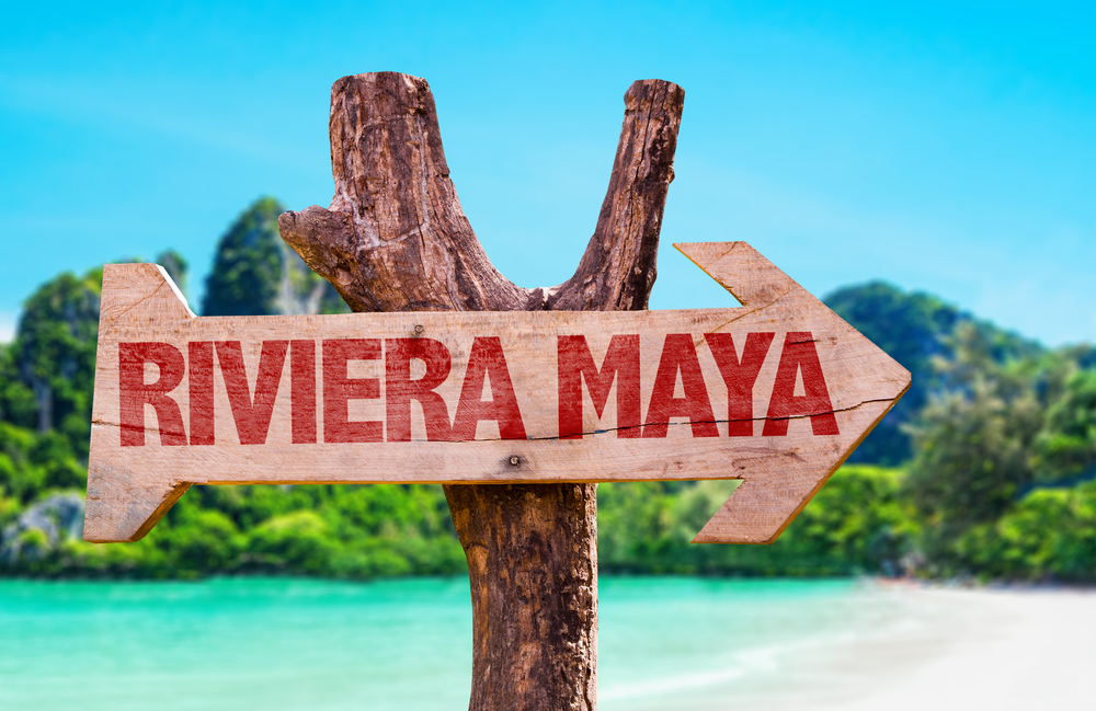 Indicator din lemn cu inscripția Riviera Maya lângă apă turcoaz