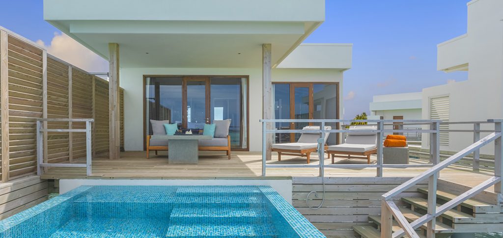 Piscină privată lângă o vilă cu terasă și vedere la ocean.
