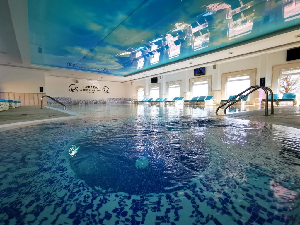 Piscină interioară cu plafon decorat cu cer albastru