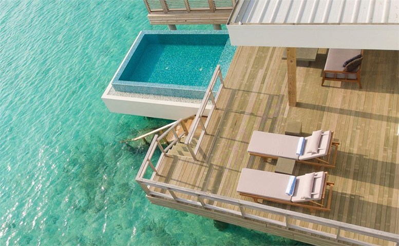 Terasă din lemn cu piscină privată deasupra apei turcoaz
