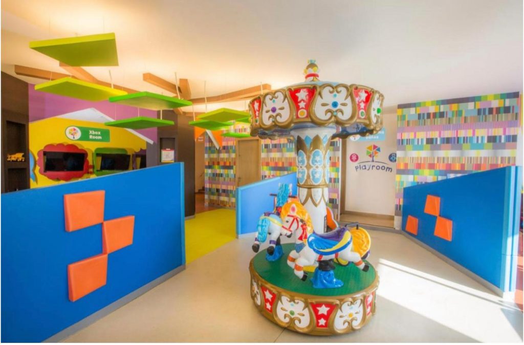 Spațiu de joacă interior cu jucării colorate și mobilier pentru copii.