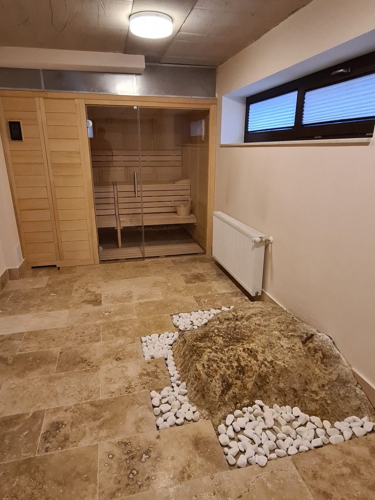 Încăpere placată cu piatră, cu o cabină de saună.