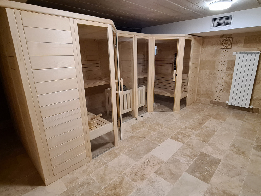 Două cabine din lemn cu uși vitrate, într-o încăpere placată.