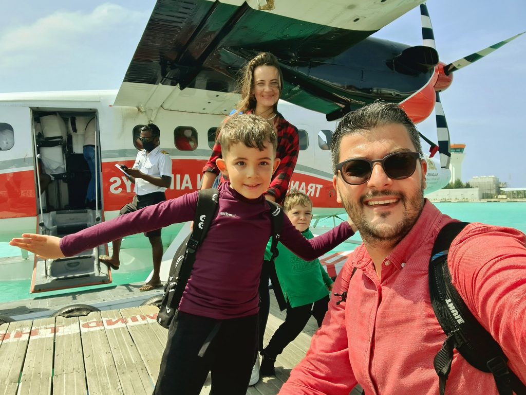 Bărbat și copii fotografiindu-se lângă un hidroavion.