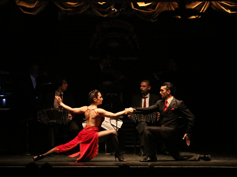 Cuplu dansând tango, cu muzicieni în fundal