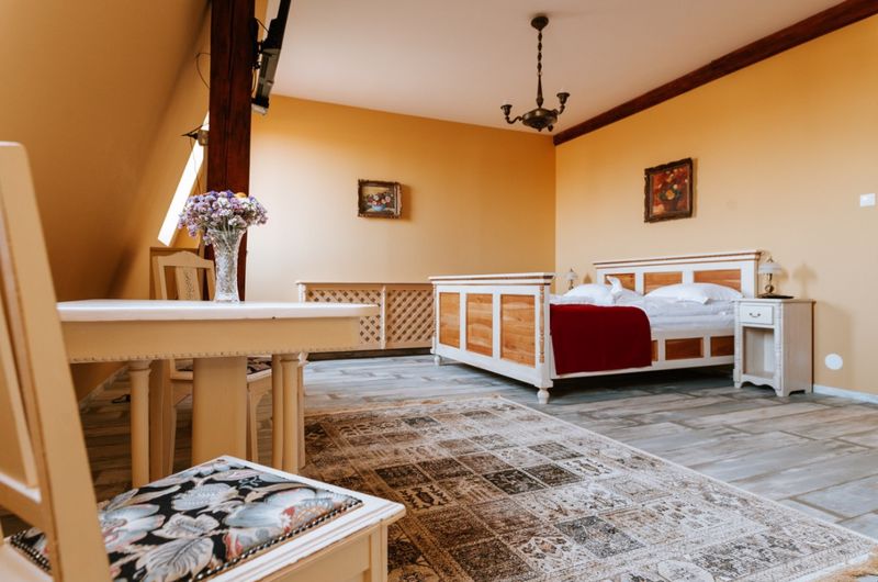 Cameră cu paturi din lemn și covoare cu modele.