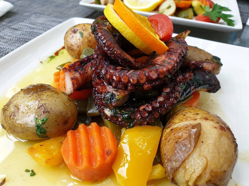 Tentacule cu cartofi și legume servite pe farfurie.