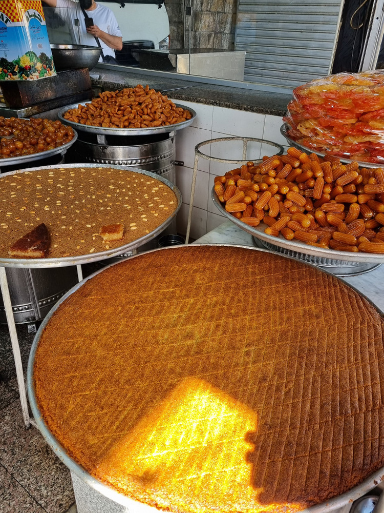 Tăvi rotunde cu dulciuri aurii și produse de patiserie.