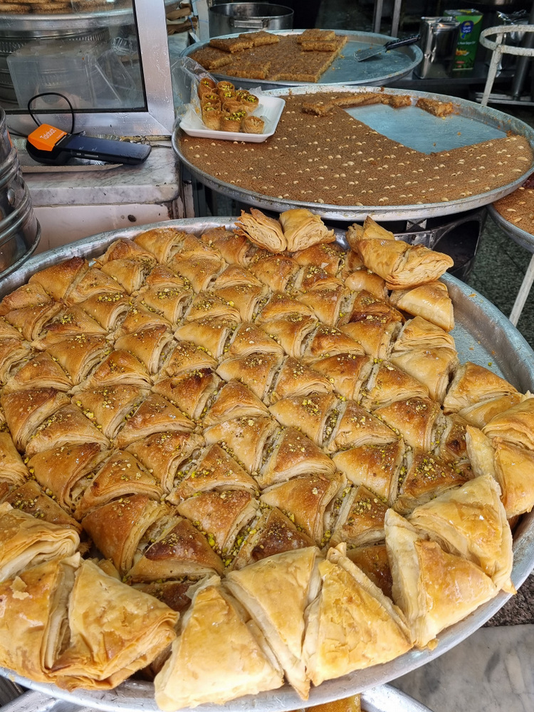 Tăvi cu produse de patiserie aurii, porționate în forme triunghiulare.