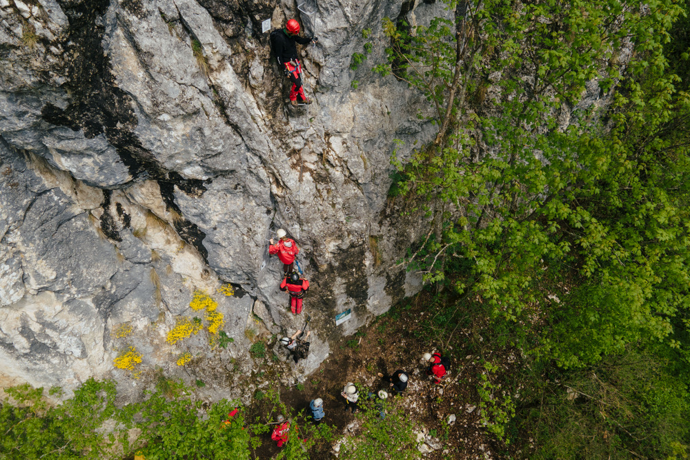 Persoane echipate pe un traseu vertical de escaladă