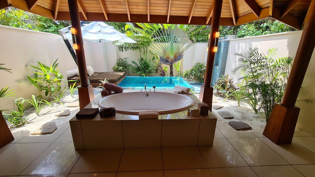 Cadă rotundă într-un spațiu deschis spre piscină și vegetație.