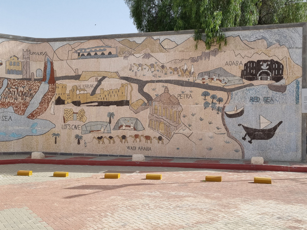 Mozaic mural mare cu reprezentări de clădiri și trasee.