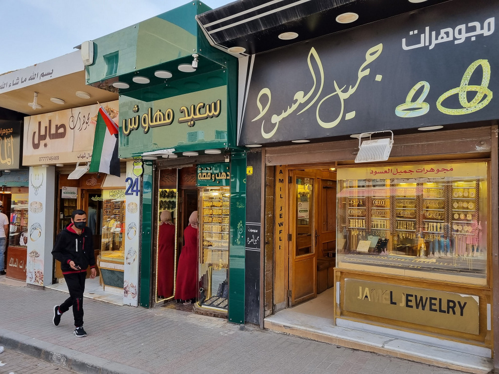 Magazine alăturate cu firme în limba arabă și vitrine stradale.