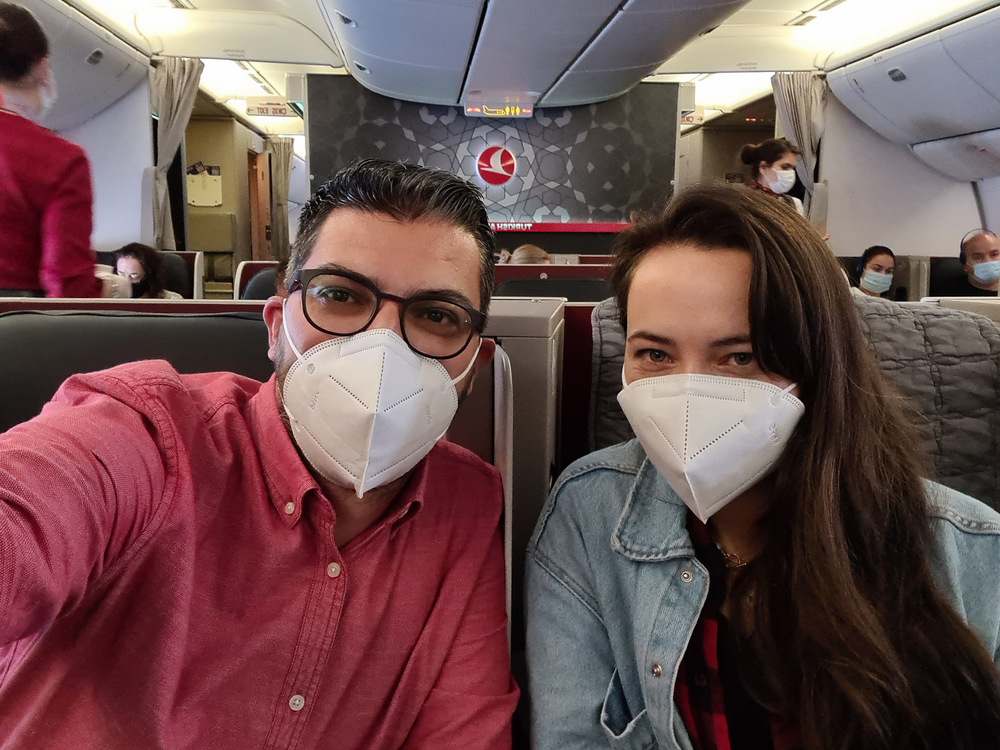 Doi adulți cu măști fotografiindu-se în cabina avionului.
