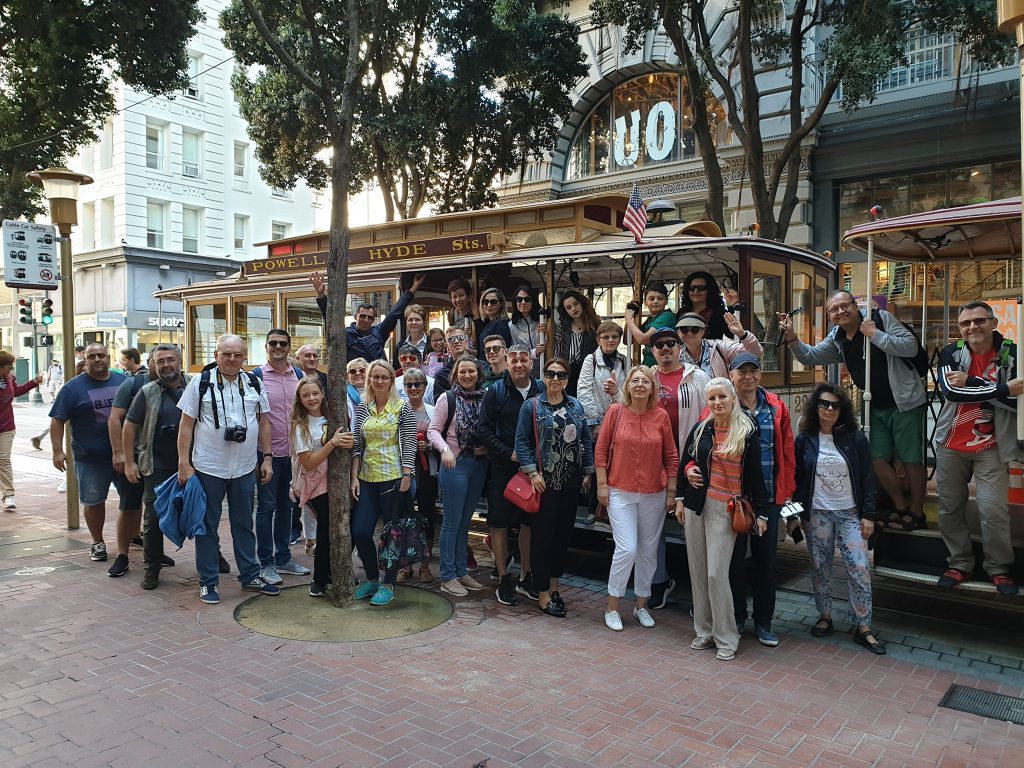 Grup de vizitatori în fața unui restaurant
