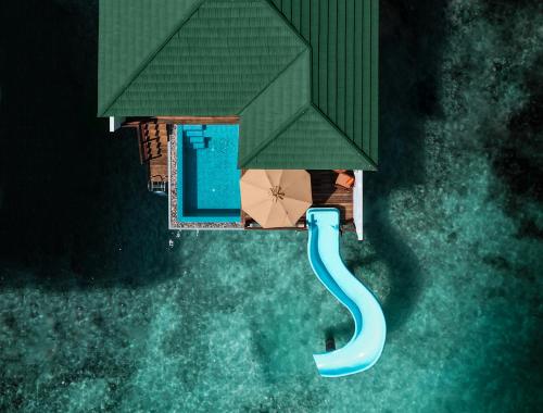 Vedere aeriană a unei vile cu piscină și tobogan spre mare.