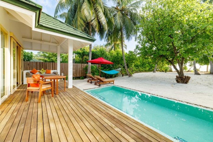 Piscină privată lângă terasa din lemn a unei vile.