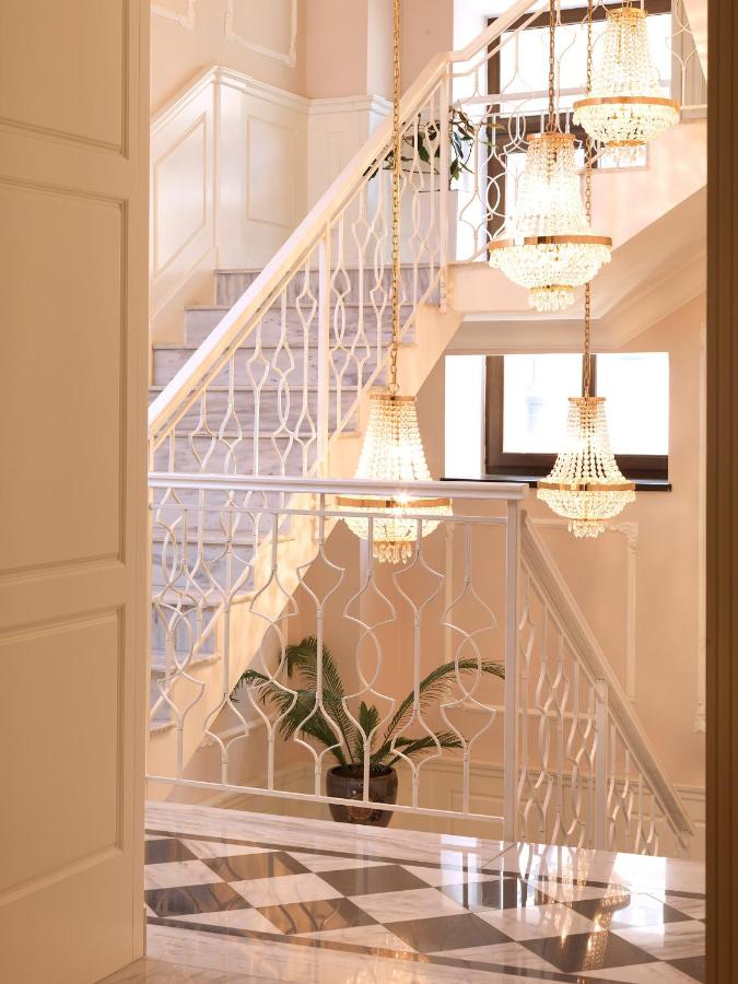 Scară interioară luminoasă cu balustradă albă și corpuri decorative suspendate.
