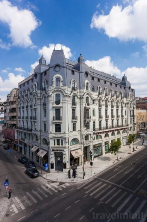 Clădire de colț cu fațadă ornamentată, lângă o intersecție.