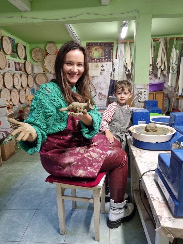 Femeie ținând obiecte ceramice într-un atelier
