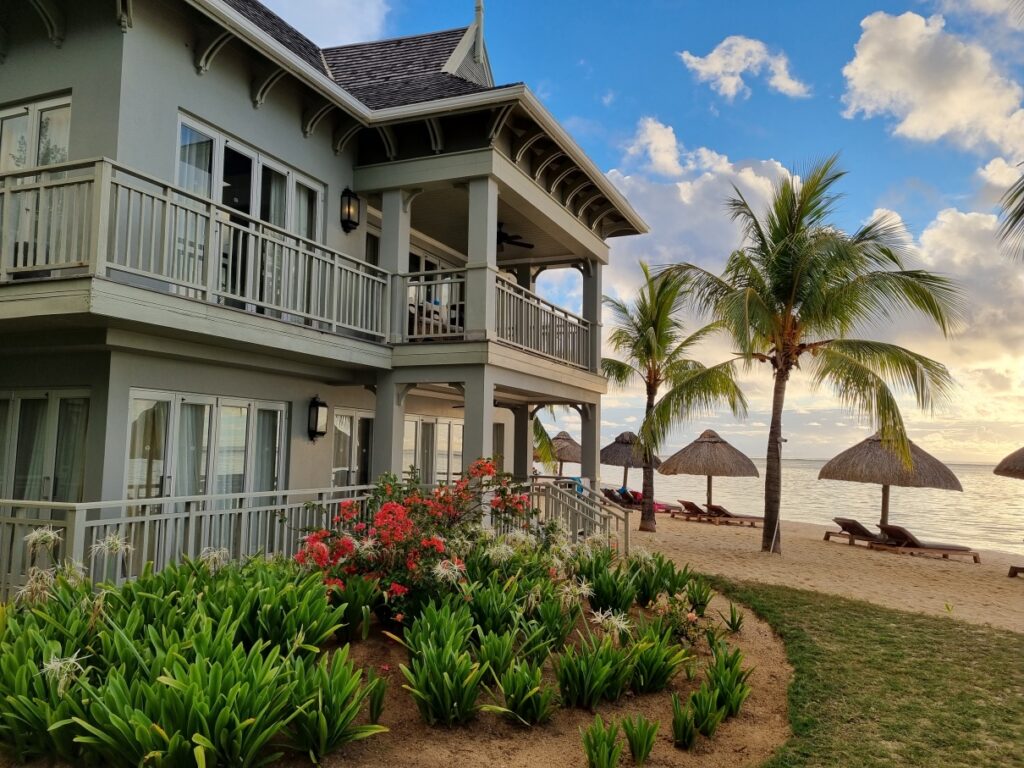 Clădire cu balcoane, într-o grădină tropicală cu palmieri