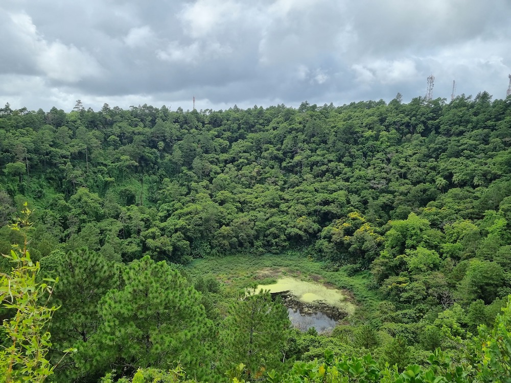 Craterul vulcanic Trou aux Cerfs acoperit de pădure, cu un mic lac