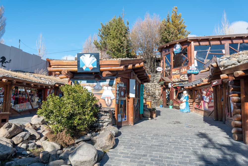 Intrare într-un spațiu comercial rustic, decorată cu pietre și lemn.