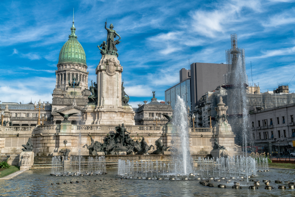 Clădiri istorice cu cupole și monument într-o piață