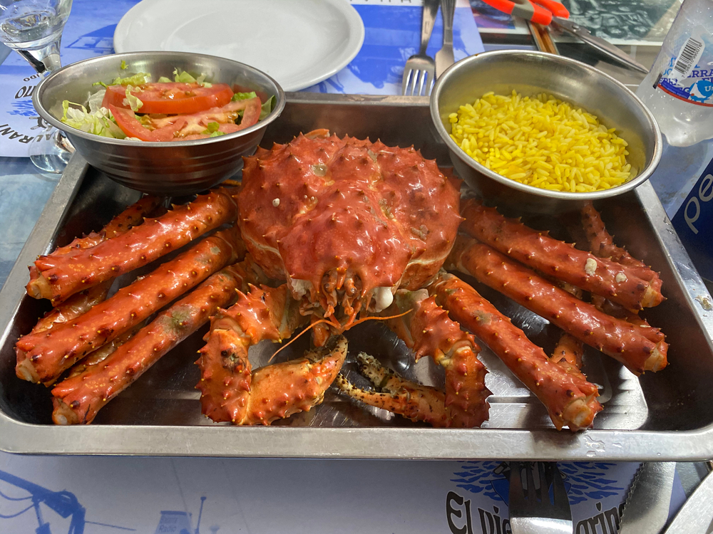 Crab servit pe un platou, lângă boluri cu sos