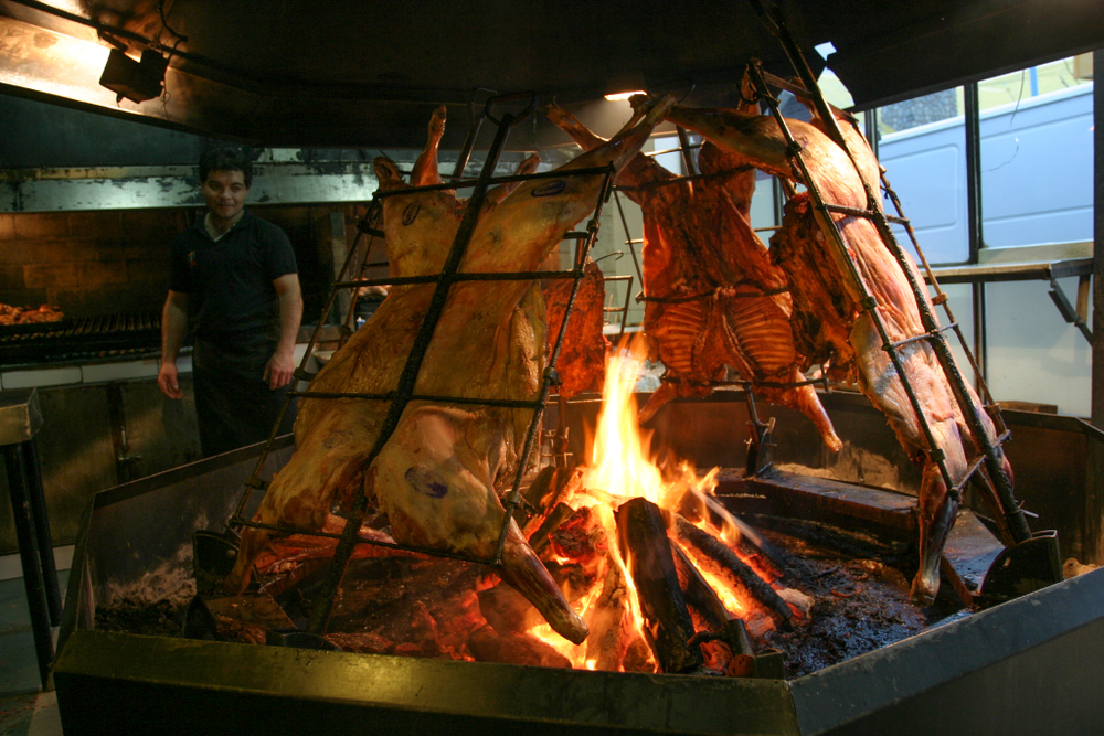 Carne suspendată lângă foc, într-un spațiu de gătit