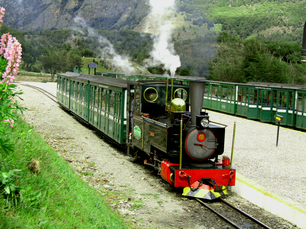 Tren cu locomotivă verde, într-o vale montană