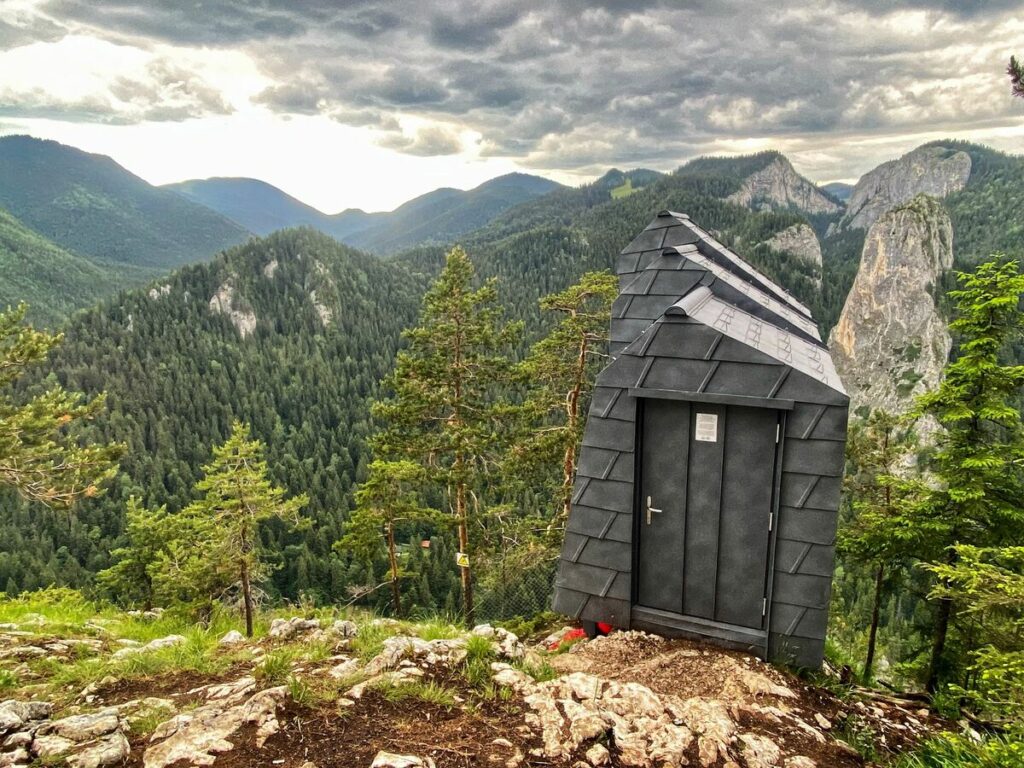 Cabană mică de lemn deasupra unei văi montane
