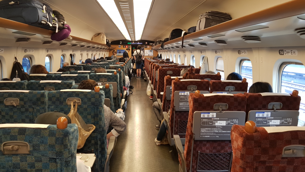 Pasageri așezați în interiorul unui vagon de tren