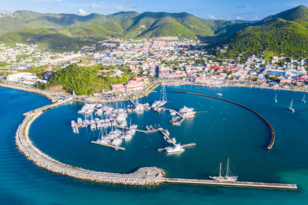 Vedere aeriană asupra unui port de agrement protejat de diguri curbe.