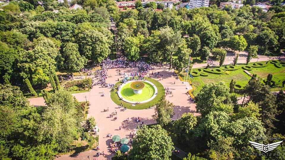 Vedere aeriană asupra unei fântâni circulare într-un parc cu alei.
