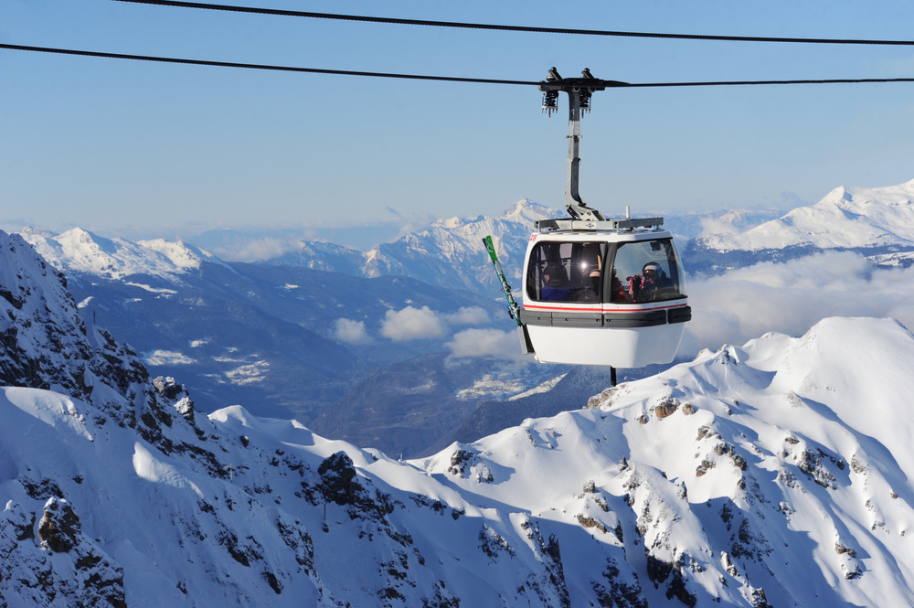 Cabină de teleferic deasupra unor pante montane înzăpezite