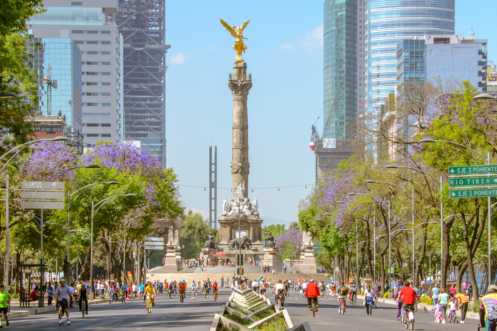 Monument cu coloană și statuie, între clădiri din Mexico City