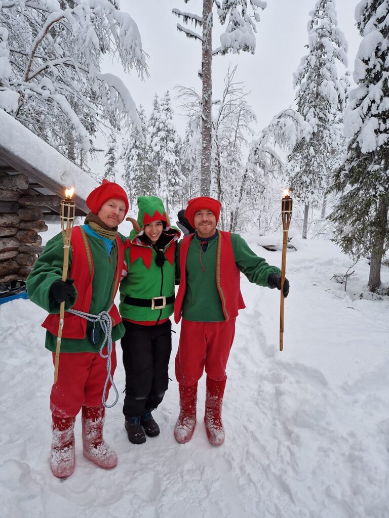 Persoane în costume festive roșii pe un drum înzăpezit