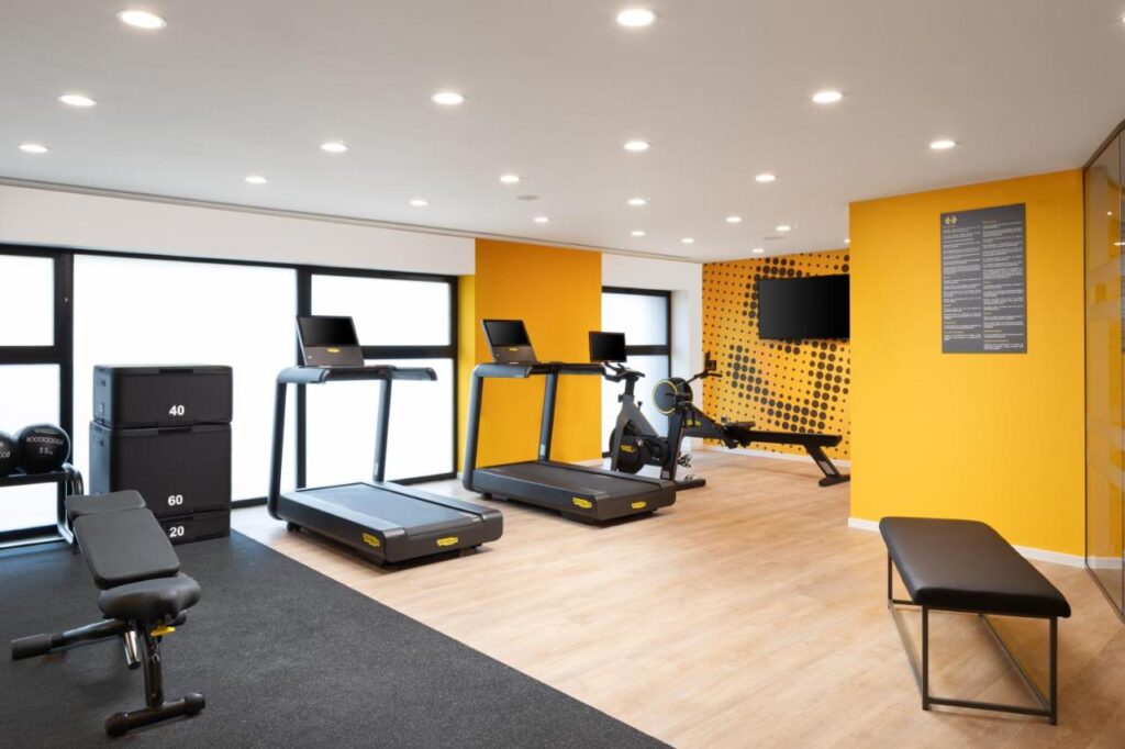 Sală de fitness cu aparate și perete galben