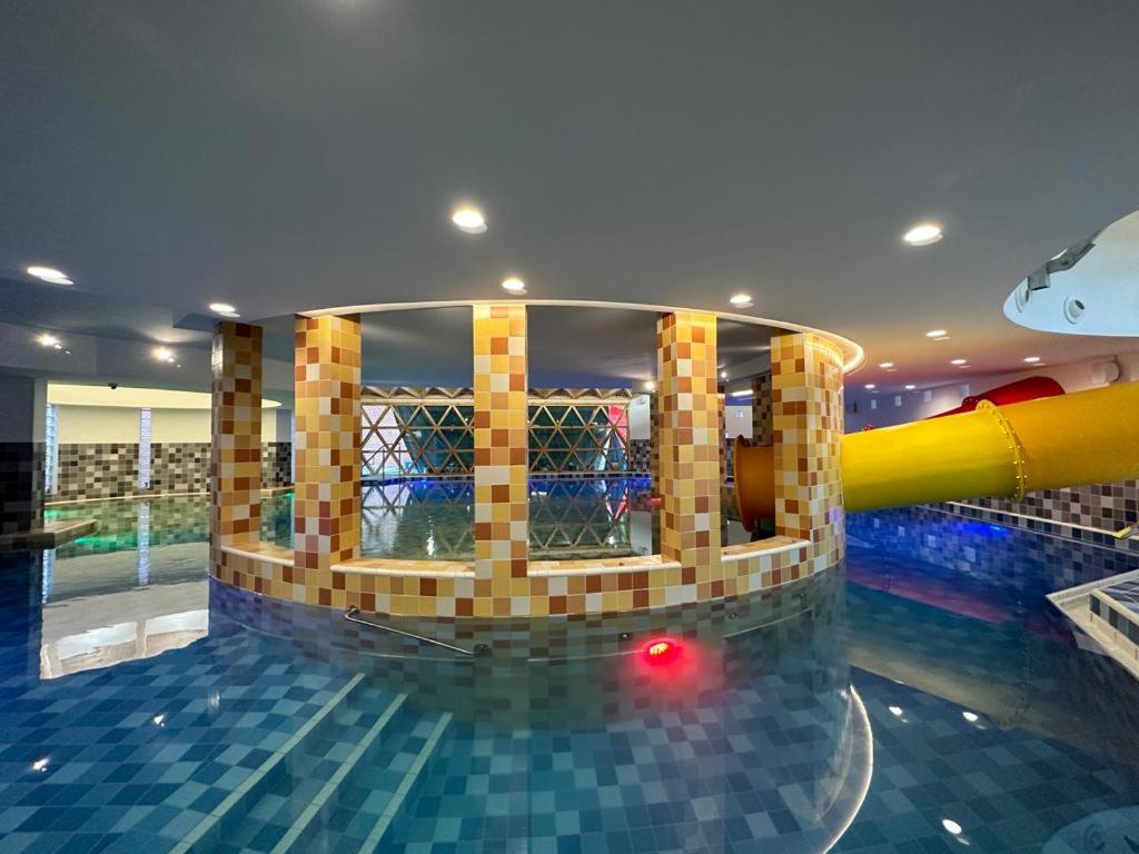 Piscină interioară cu mozaic colorat și lumini