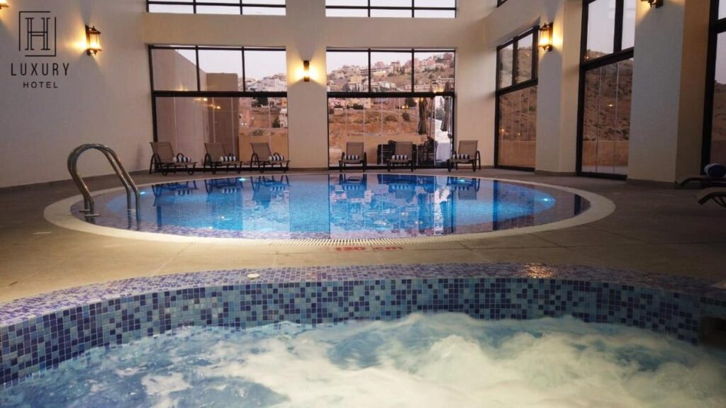Bazin cu apă învolburată lângă o piscină interioară.