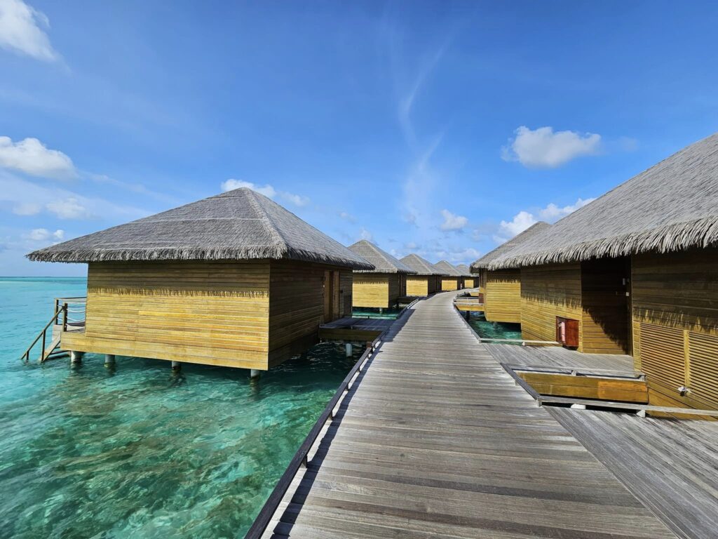Ponton din lemn între bungalouri construite deasupra apei.