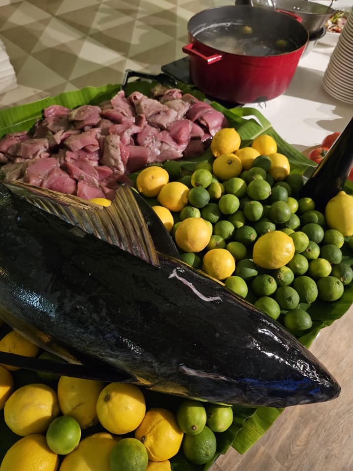 Pește întreg expus lângă citrice și bucăți de carne.