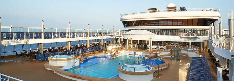 Piscină exterioară și șezlonguri pe puntea unui vas.