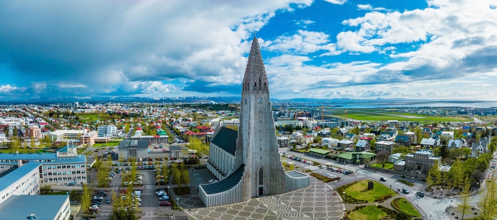 Hallgrimskirkja deasupra clădirilor din Reykjavik, sub cer albastru