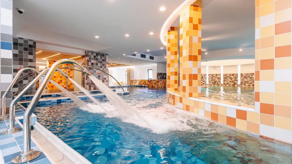 Piscină interioară cu apă albastră și balustrade metalice