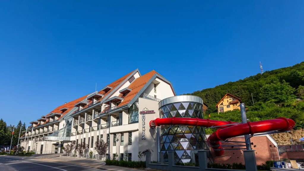 Clădire hotelieră cu balcoane și tobogane roșii