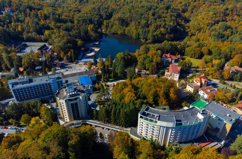 Clădiri printre arbori, lângă un lac din Sovata